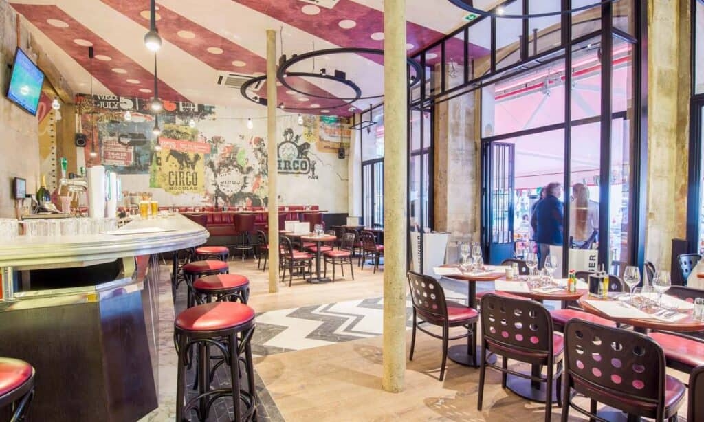 Urban trendy event venue in Paris featuring colourful wall murals and wooden floors.