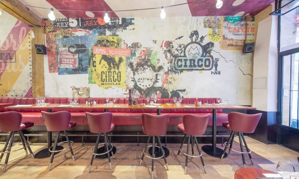 Urban trendy event venue in Paris featuring colourful wall murals and wooden floors.