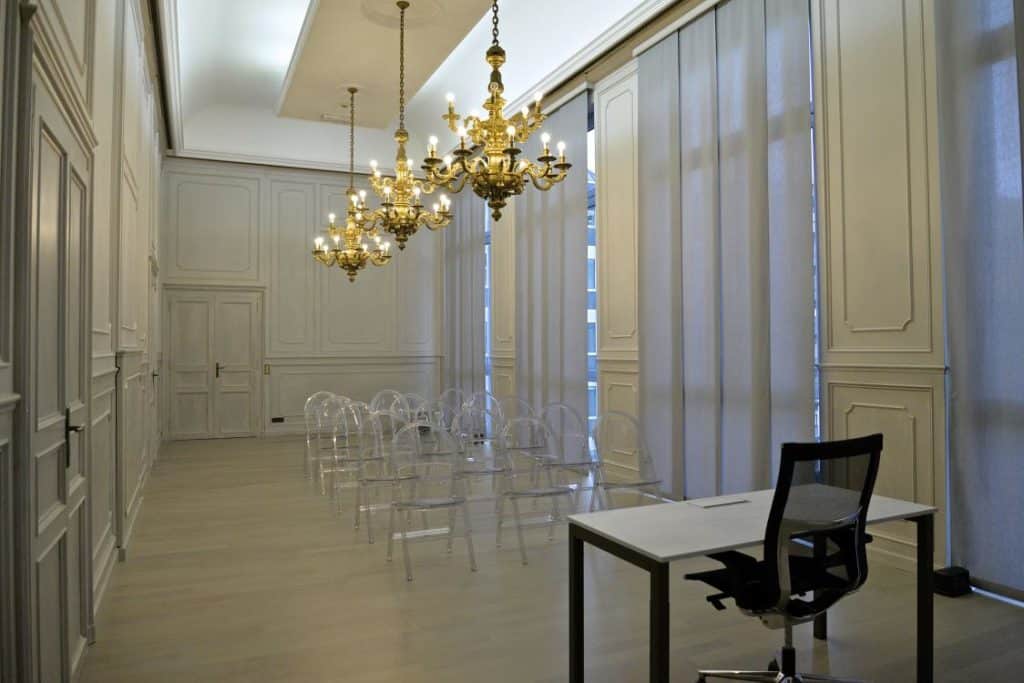Classy meeting space for corporate gatherings featuring wood panelling, parquet floor and high ceilings.