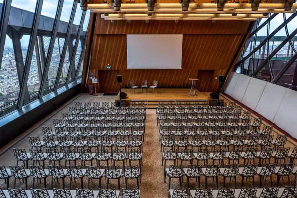 Spacious auditorium with floor-to-ceiling windows and a view of Paris