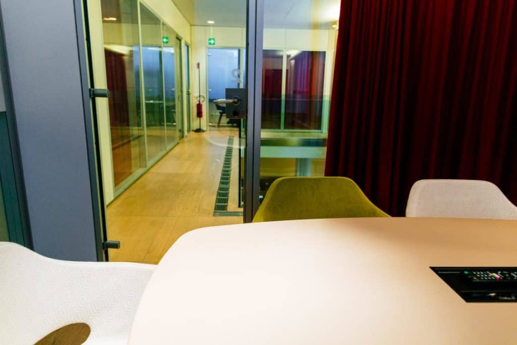 Creative room for small meetings. Venue with wooden floors, velvety red curtains and modern furniture.