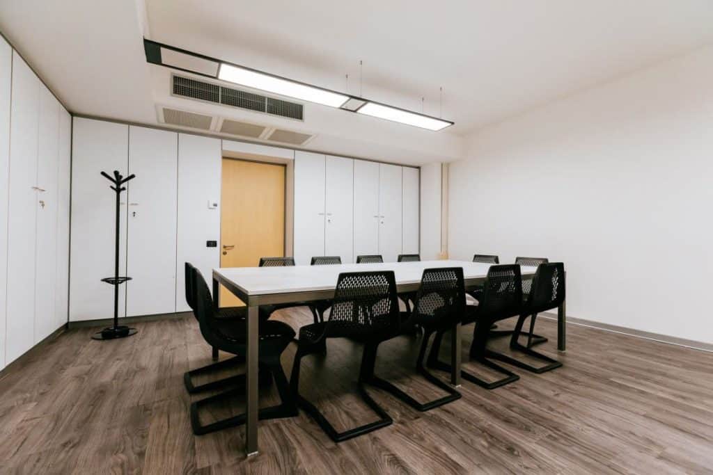 Radiant boardroom with a fresh atmosphere featuring parquet floors and white panelling.
