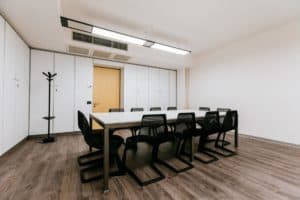 Radiant boardroom with a fresh atmosphere featuring parquet floors and white panelling.