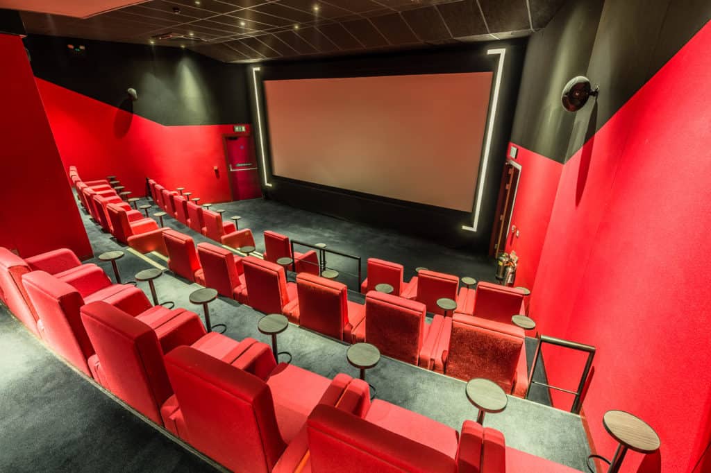 Red cinema room for presentations with a retro look and high-end technology.