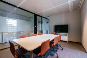 Sleek meeting room with a cosy atmosphere featuring carpeted floors and contemporary furniture.