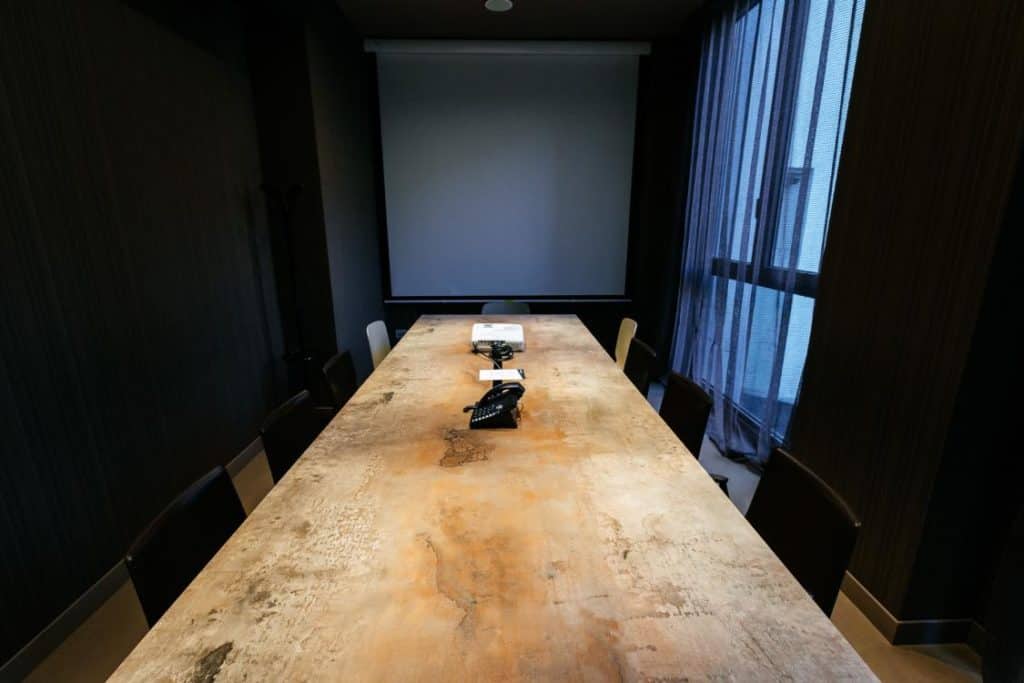 Stylish meeting room with a rustic touch featuring dark tones and wooden furniture.