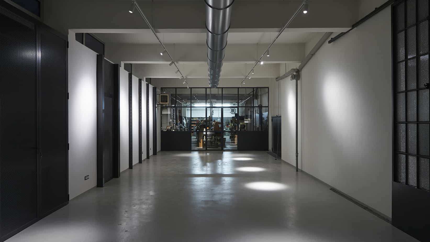 Industrial space with a unique atmosphere featuring high ceilings, concrete floors and black metal frames.