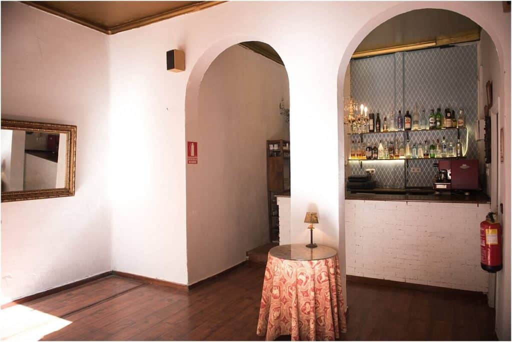 Vibrant venue with a classic Spanish look showcasing polished wooden floors, arched doorways and folkloric blue wallpaper.