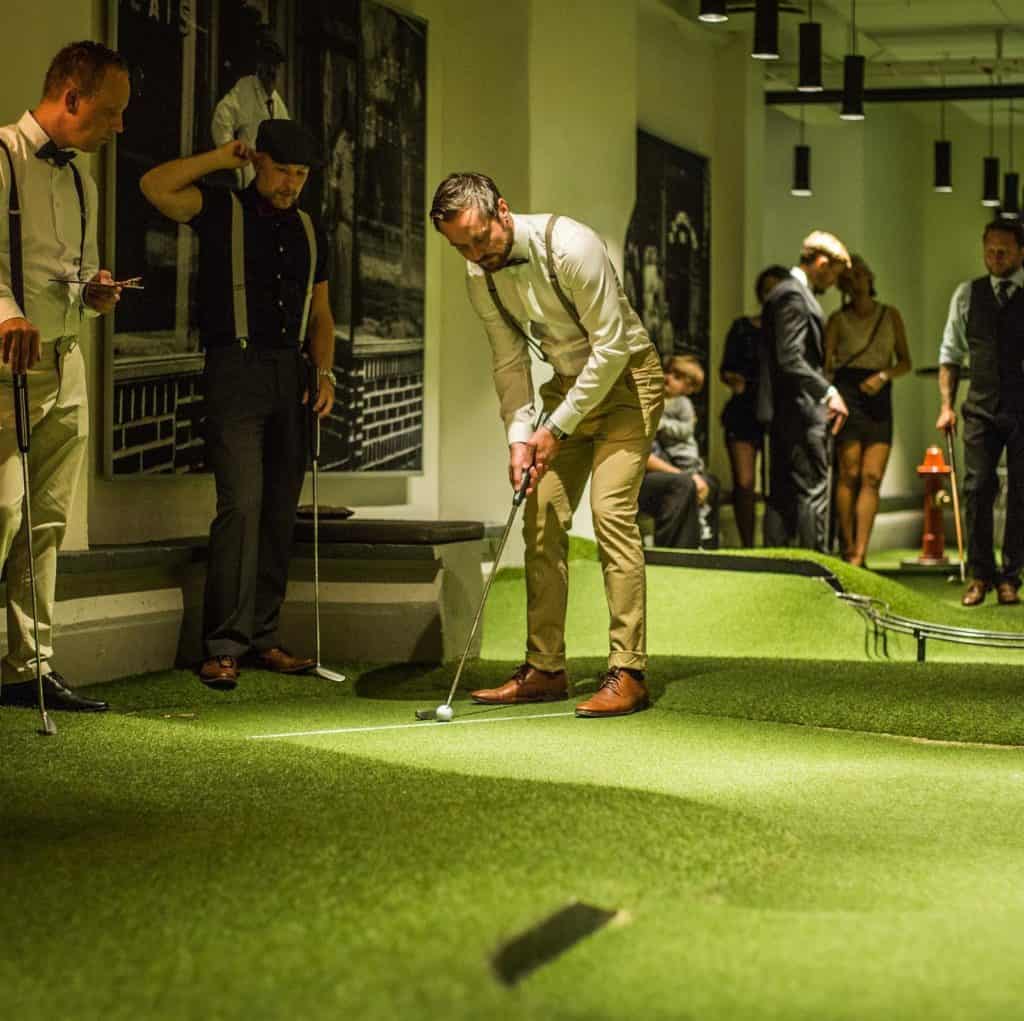 Man playing mini-golf in a event venue