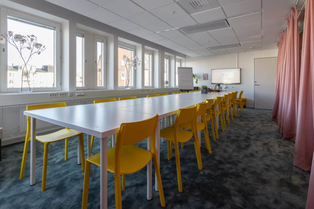 Meeting space with natural light and yellow chairs